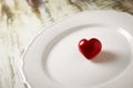 A red stone heart in a white plate Royalty Free Stock Photo