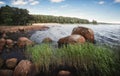 Red stones going bathe. Baltic shore with granite rocks and beach at background. Gulf of Finland