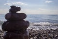 Red stones Pyramid balance on the sand of the beach. Focus on the sea Royalty Free Stock Photo