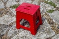 Red stool on a garden path. Royalty Free Stock Photo