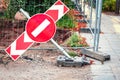 Red stop road sign on red arrow sign falling on ground near construction site and road Royalty Free Stock Photo