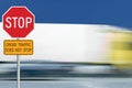 Red stop road sign, motion blurred truck vehicle traffic in background, regulatory warning signage octagon, white octagonal frame Royalty Free Stock Photo