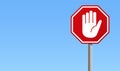 Red stop sign with big hand symbol and blue background Royalty Free Stock Photo