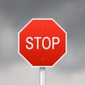 Red stop sign on gray sky background