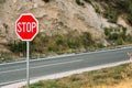 Red stop sign near the mountain road Royalty Free Stock Photo