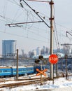 Red stop sign at the railway crossing at the entrance to the city against the background of the winter season Royalty Free Stock Photo