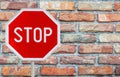 Red stop sign on a rod with Background of red brick wall Royalty Free Stock Photo