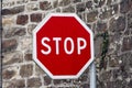 Red stop sign on stone wall in France Royalty Free Stock Photo