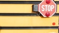 Red stop sign, yellow school bus in USA. Schoolbus or shuttle, safety on road.