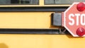 Red stop sign, yellow school bus in USA. Schoolbus or shuttle, safety on road.