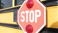 Red stop sign, yellow school bus in USA. Schoolbus or shuttle, safety on road.