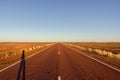 red straight road with red dessert on the Stuart Highway north of copper pedy, South Australia Royalty Free Stock Photo