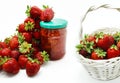 Red strawberries in the basket and on the table isolated on white Royalty Free Stock Photo