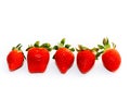 Red strawberries of different shapes with green leaves, side by side, isolated on a seamless white background. Royalty Free Stock Photo