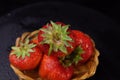 Red strawberries with drops in small basket on black background Royalty Free Stock Photo