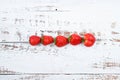 Red strawberries lined up on a white wooden background