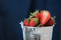 Red strawberries in a metal bucket closeup in a blue background. Multivitamin cocktail. Healthy lifestyle. Summer fresh taste. Royalty Free Stock Photo