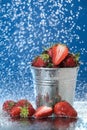 Red strawberries in a metal bucket closeup in a light blue background. Multivitamin cocktail. Healthy lifestyle.