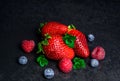 Red strawberry blueberry raspberry fresh mint on black background Royalty Free Stock Photo