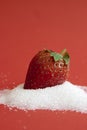 Red Strawberry drops on white sugar on red background