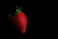 Red strawberry fruit close up skin texture on a black background Royalty Free Stock Photo