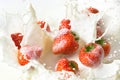 Red strawberry fruits falling into the milk Royalty Free Stock Photo