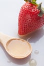 Red strawberry with honey on wooden spoon on white background Royalty Free Stock Photo