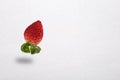 Red strawberry with levitation on white paper background Royalty Free Stock Photo