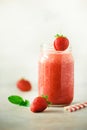 Red strawberry milkshake in glass jar on grey background with copy space. Summer food concept, vegan diet. Pink smoothie Royalty Free Stock Photo