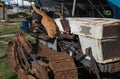 Red stray cat on a rusty abandoned bulldozer