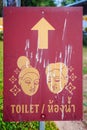 Red street sign of toilet direction in Thai and English