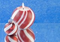 Red striped Christmas candle blue background Royalty Free Stock Photo