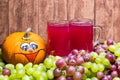 Red stum together with some green and red grapes and a pumpkin photographed in front of a piece of wood Royalty Free Stock Photo