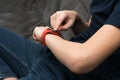 Red stylish smart watch on male wrist, side view closeup. Touch finger on screen of gadget and look time and data. Royalty Free Stock Photo