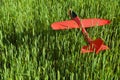 Red styrofoam plane is on grass