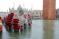 Red submerged chairs in Saint Mark Square full of water in Venic Royalty Free Stock Photo