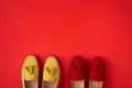 Red suede woman`s mocassin shoes over red background