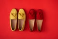 Red suede woman`s mocassin shoes over red background