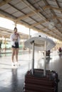 Red suitcase on platform of railway station. Travel and vacation concept. Royalty Free Stock Photo