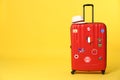 Red suitcase with travel stickers on background. Space for text Royalty Free Stock Photo