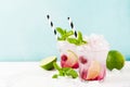 Red Summer cooling drink with ice, lime, raspberries and syrup on light background. Royalty Free Stock Photo