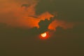 Red sun in dark clouds. Summer sunset. Fiery sun in the evening. Nature background. Dramatic dark and red sky with sunset . Heat Royalty Free Stock Photo