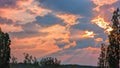 Red sun rays in the cloudy sky and glowing clouds at the sunset Royalty Free Stock Photo