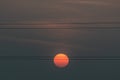 Red sun rising behind high voltage electricity power lines at dusk Royalty Free Stock Photo