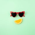 Red sunglasses and orange slice on pastel green background. Creative summer fruit background. Food concept Royalty Free Stock Photo