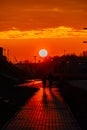 Red sunset in the city with a road and walking couple of people in love Royalty Free Stock Photo