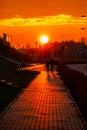 Red sunset in the city with a road and walking couple of people in love Royalty Free Stock Photo