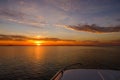 Red sunset and clouds seen from a small motor boat in calm water Royalty Free Stock Photo