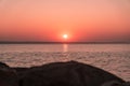 Red sunset over the sea with blurred rocky foreground, spring scene, selective focus, Shallow depth of field Royalty Free Stock Photo