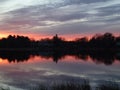 Red sunset reflected over tranquil pond